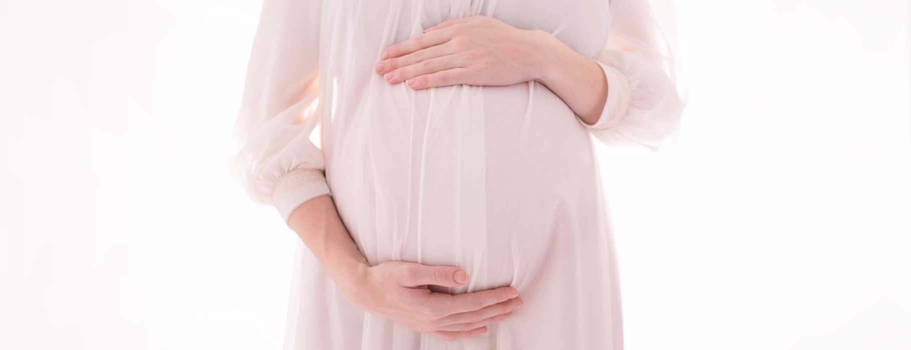 Image of pregnant woman hugging belly with her hands
