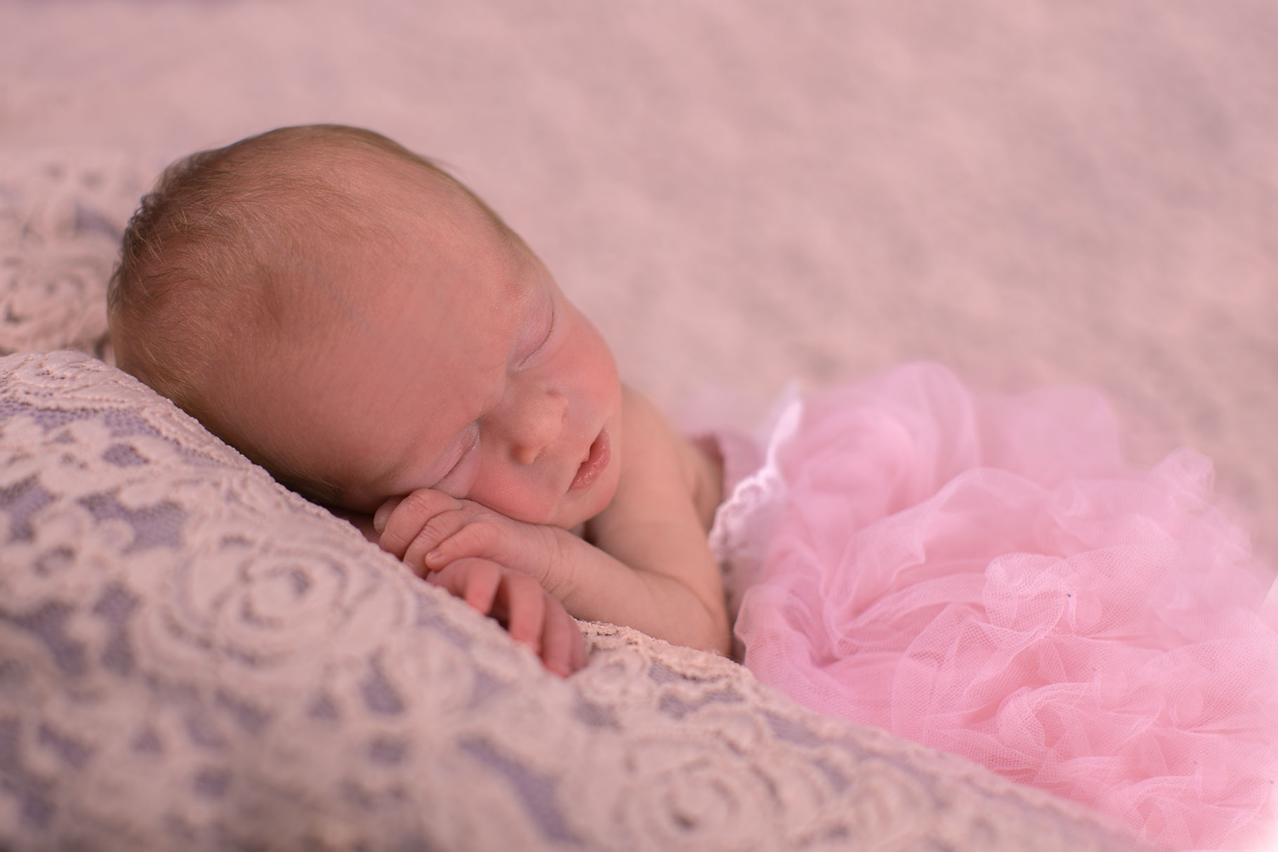 Image of baby girl asleep with her head on her hands