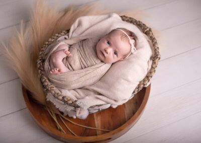 Newborn baby girl looking into a camera during newborn session