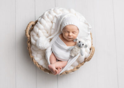 Baby wearing white hat with big pom pom