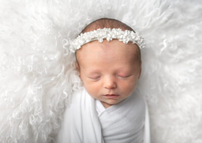 Baby posed on a white fur rug